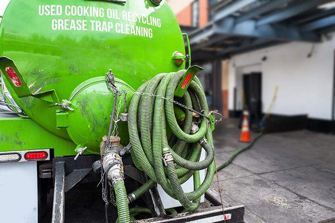 a technician pumping a grease trap in a commercial building in Culleoka, TN